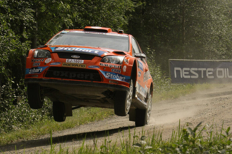 Rally car jumping on dirt road