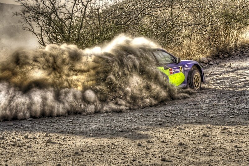 Rally Car Kicking Up Dust — Brown, Dynamic, Afternoon, Photograph, Dirt Road, Trees, Dust Cloud, Purple