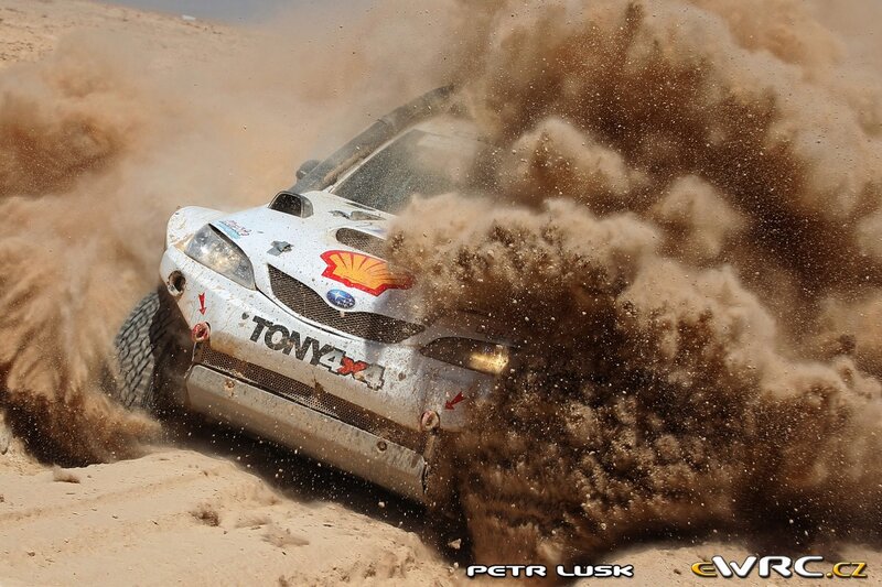 Rally car kicking up sand