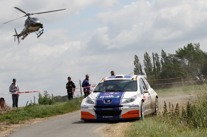 Rally Car on Dirt Road — White, Dynamic, Afternoon, Photograph, Helicopter