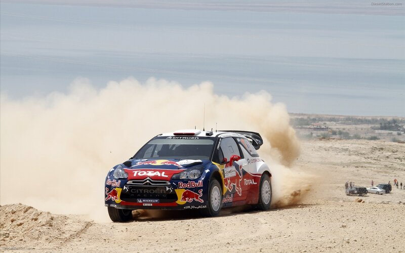 Rally car racing on a dusty track