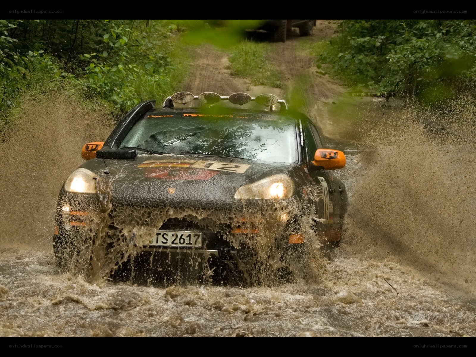 Rally car splashing through mud