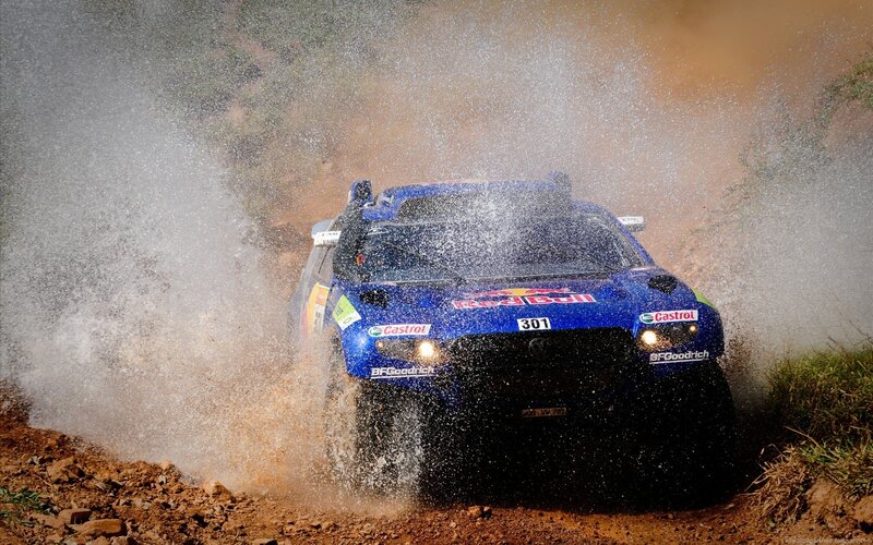 Rally car splashing through mud