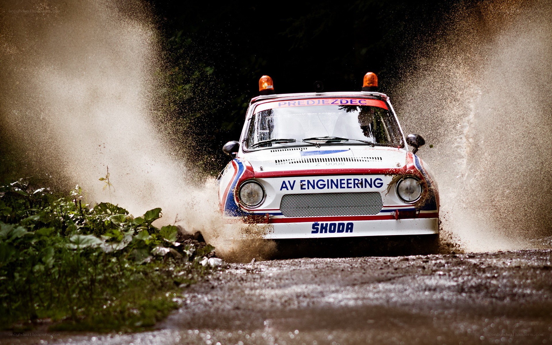 Rally car splashing through mud