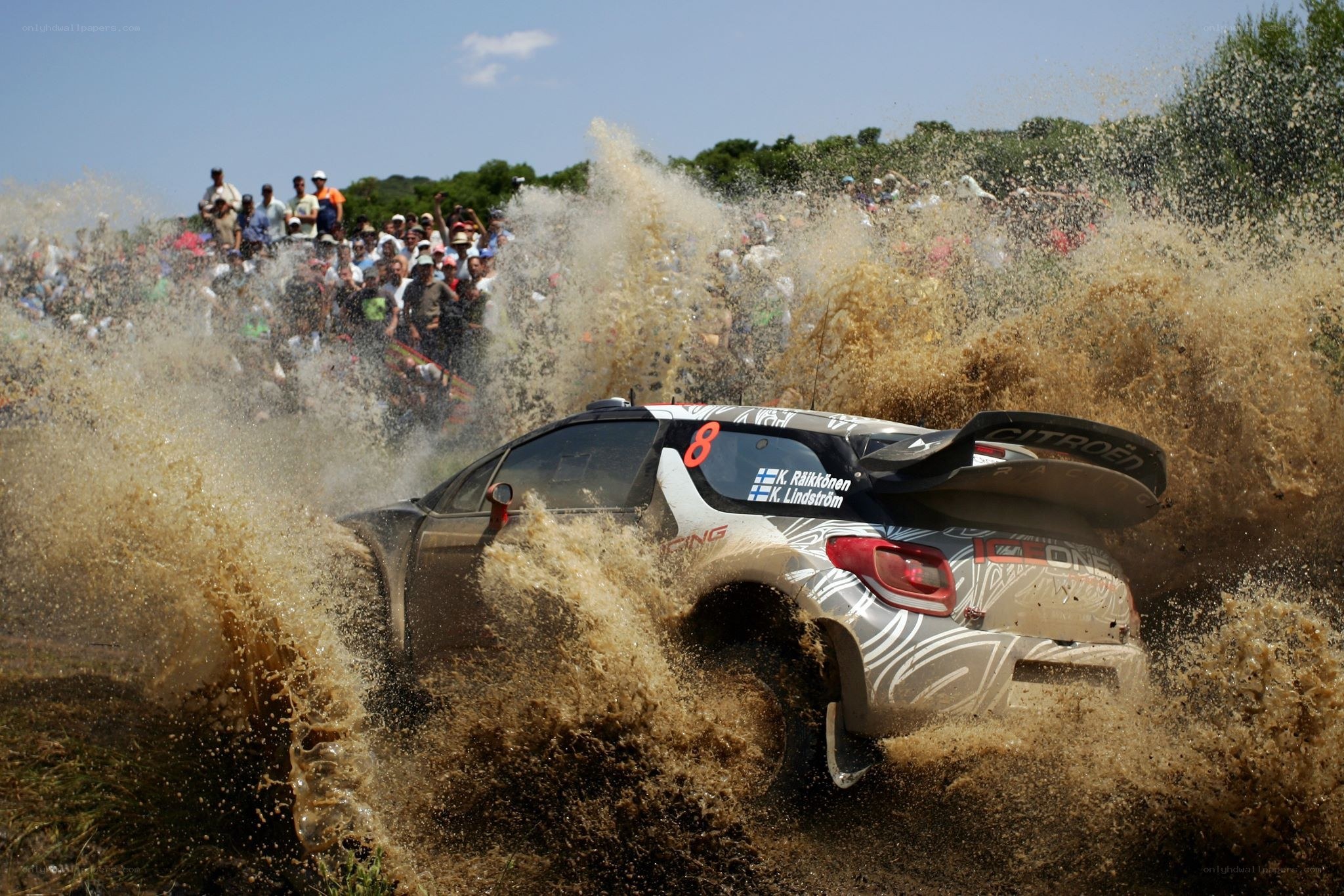 Rally car splashing through mud