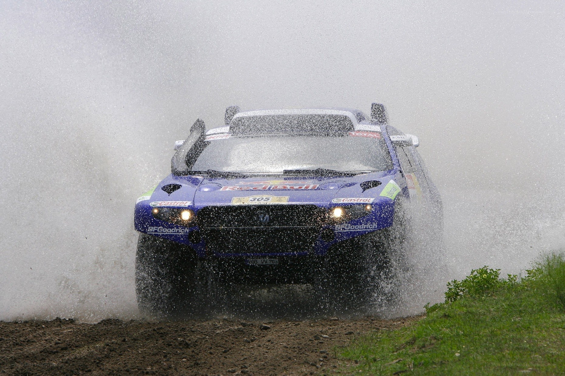 Rally car splashing through mud
