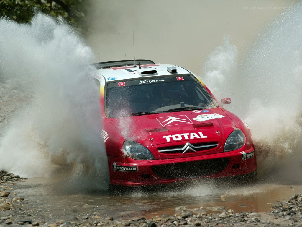 Rally car splashing through water