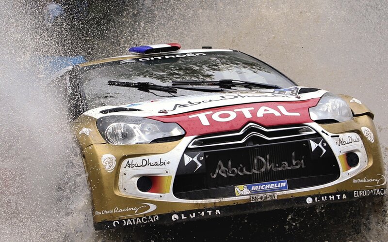 rally car splashing through water