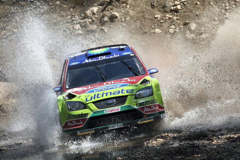 Rally car splashing through water