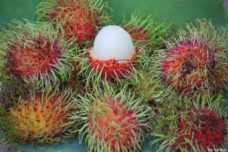 Rambutan fruits with one peeled