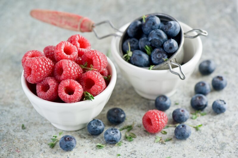Raspberries and blueberries in bowls