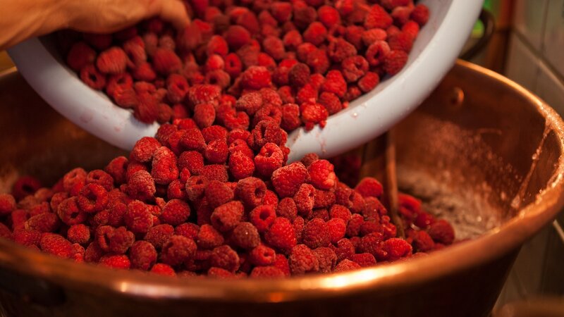 Raspberries being poured into a bowl