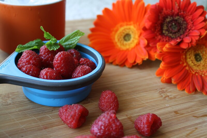 Raspberries with flowers on wood