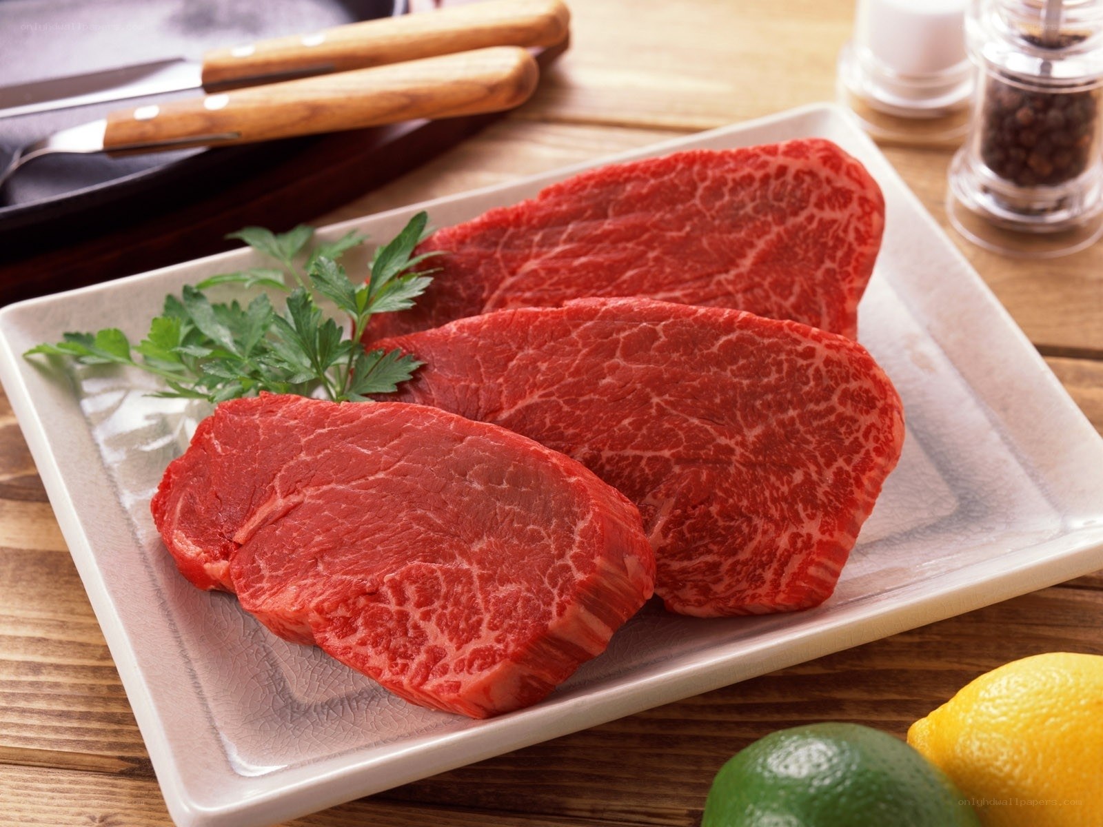 raw beef steaks on plate
