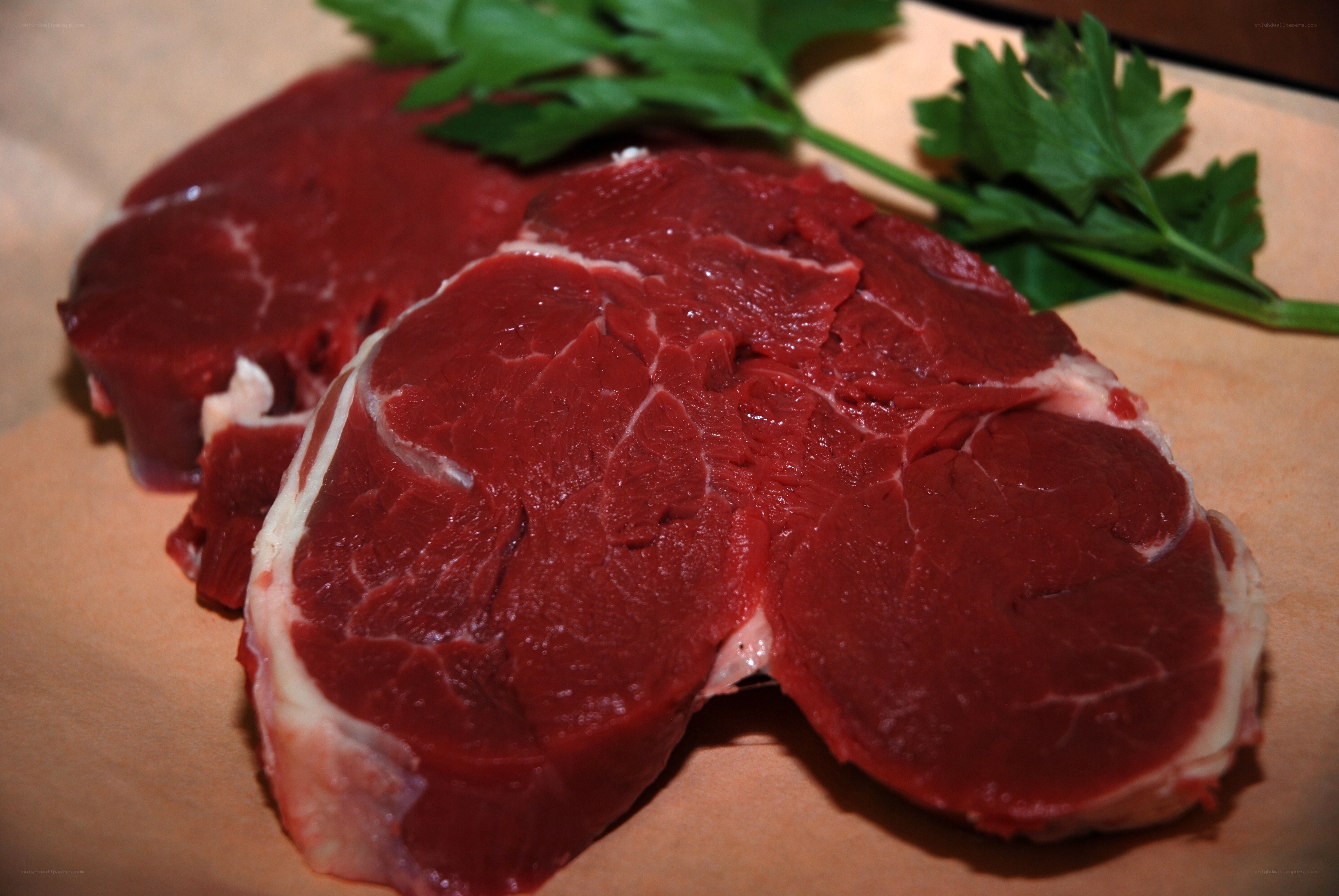 raw beef steaks with parsley