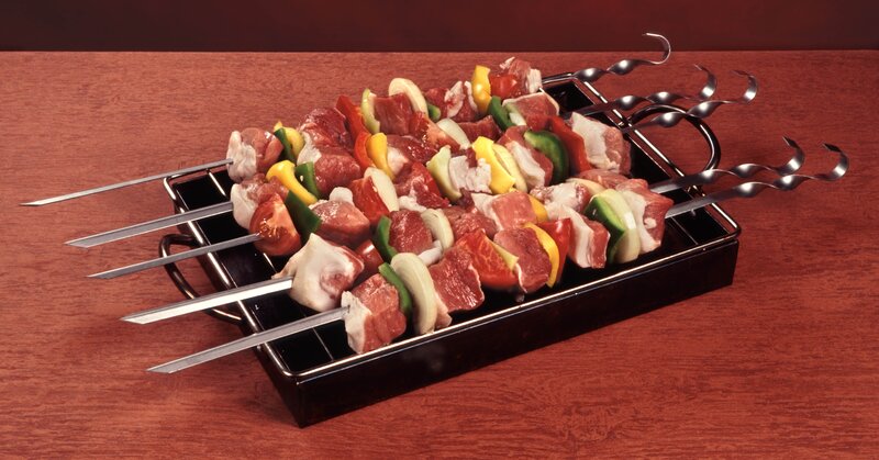 Raw meat skewers on metal tray