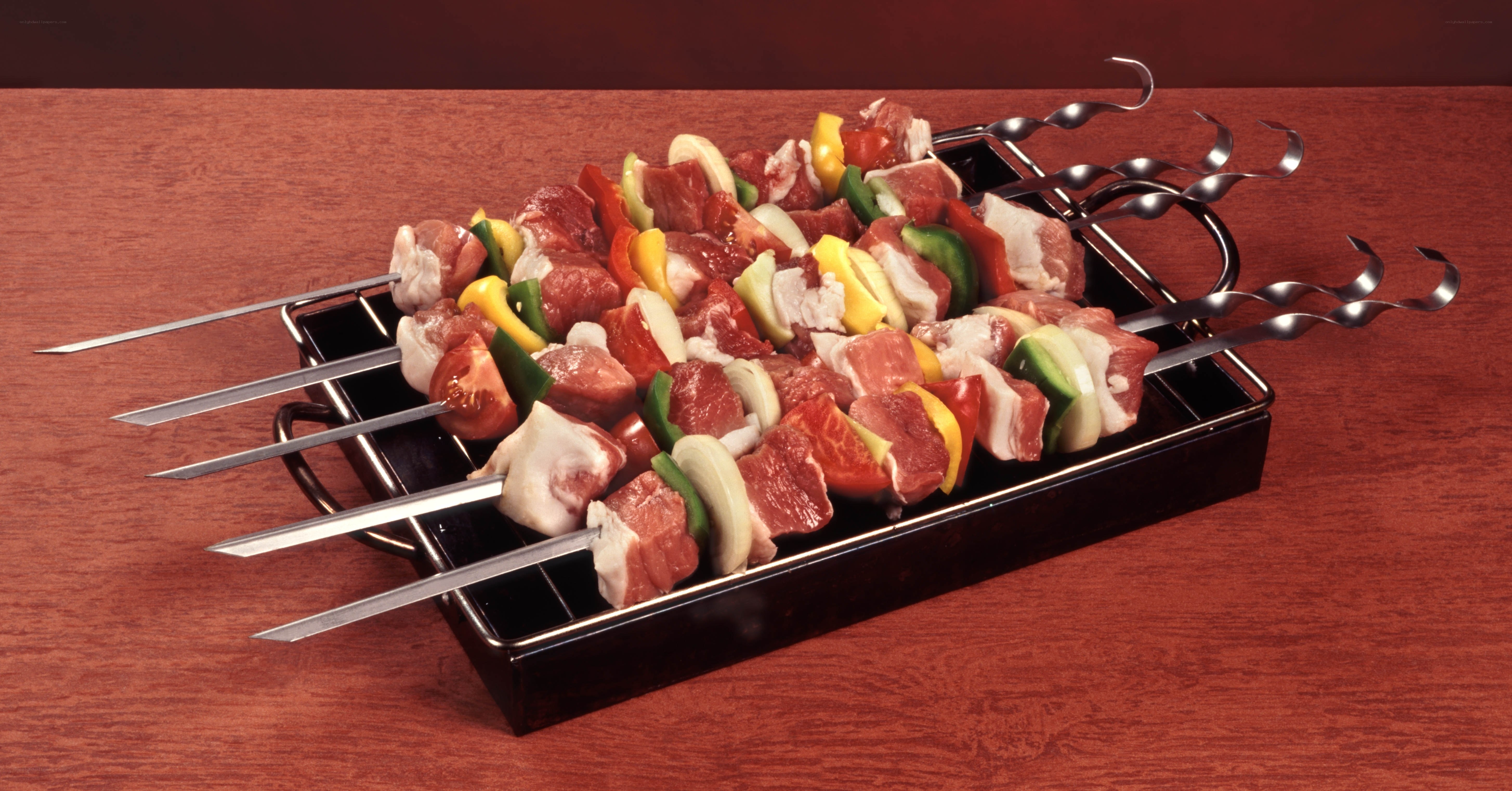 Raw meat skewers on metal tray