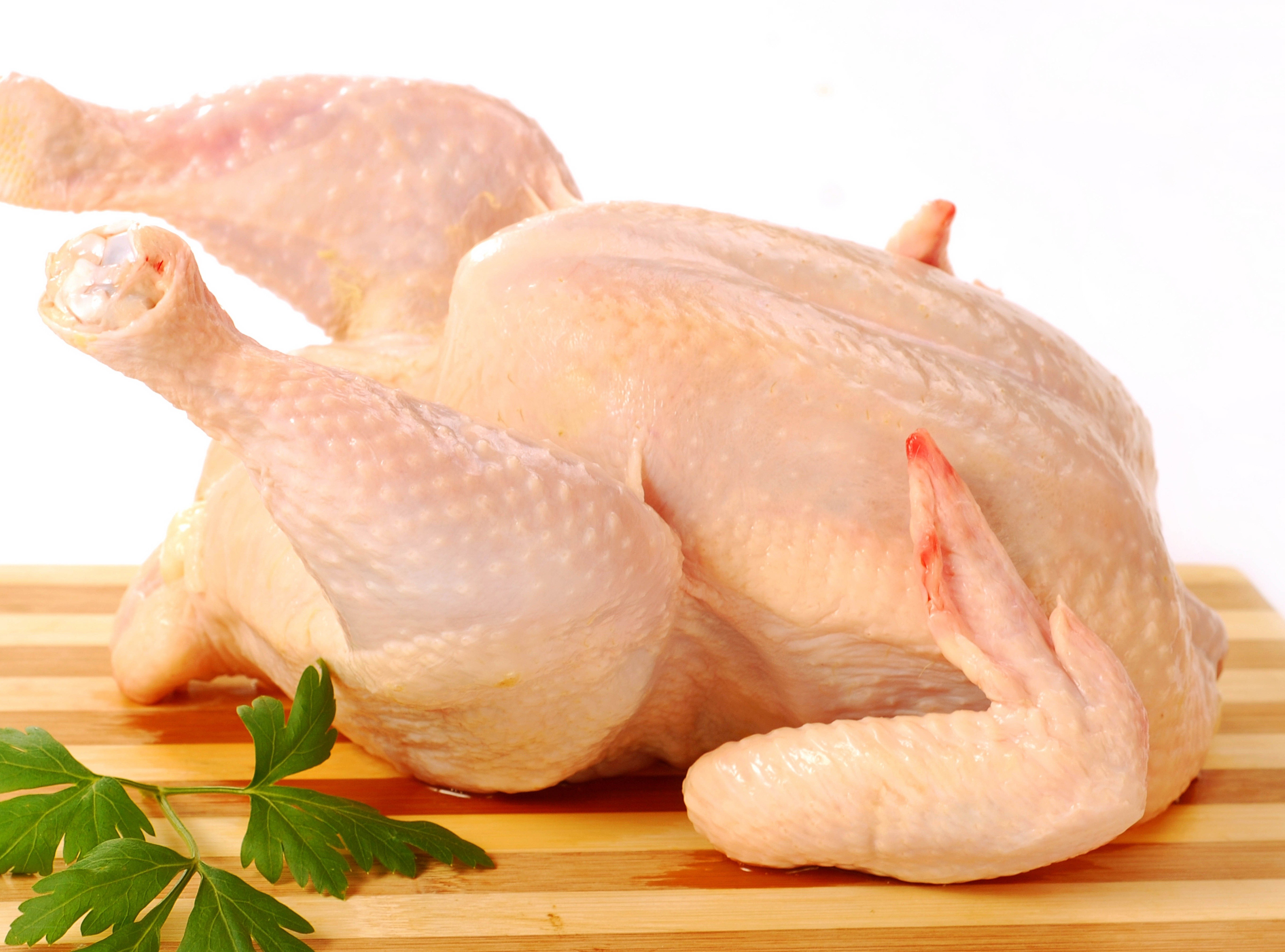 raw whole chicken on cutting board