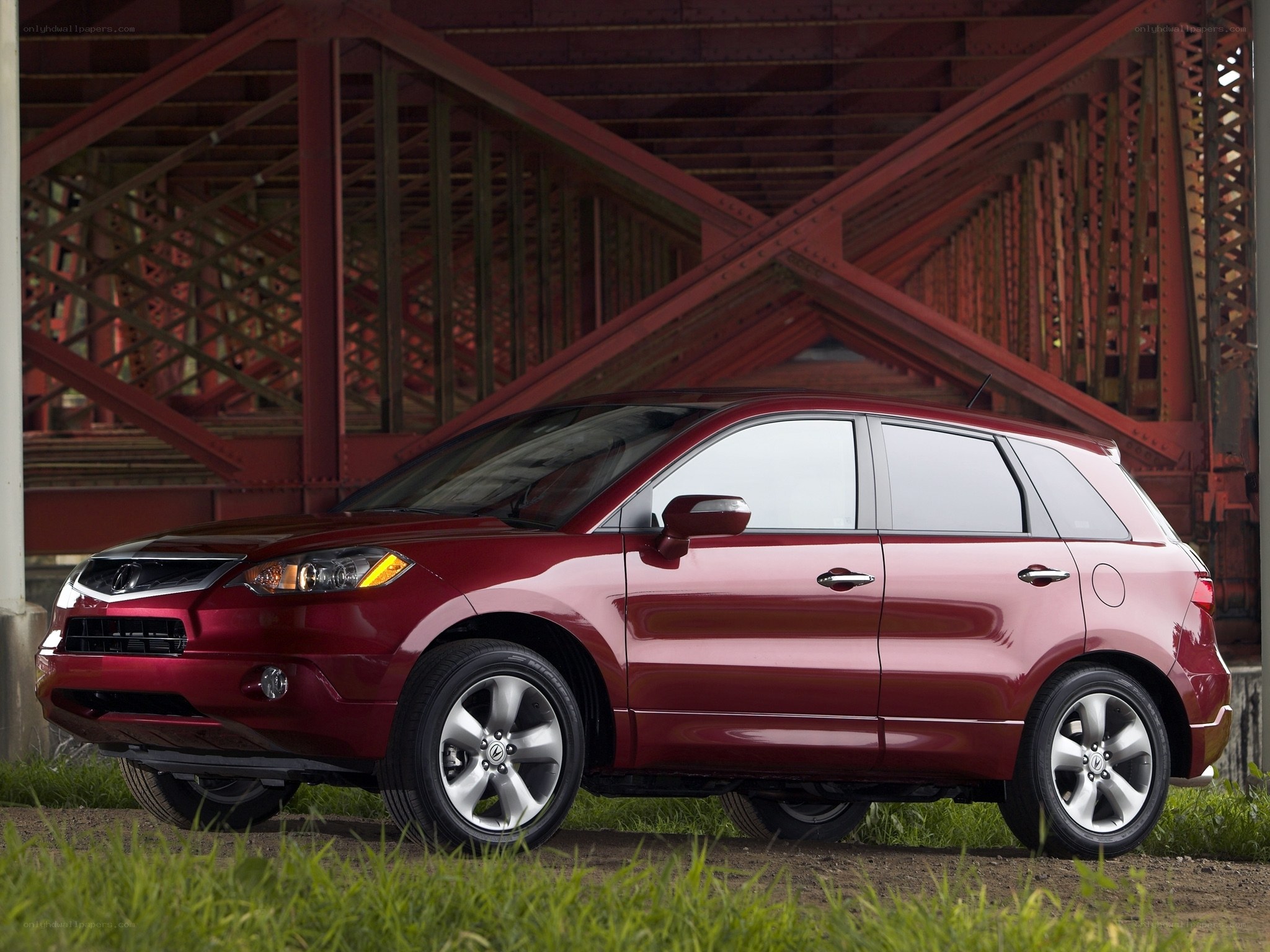 Red Acura RDX under a bridge