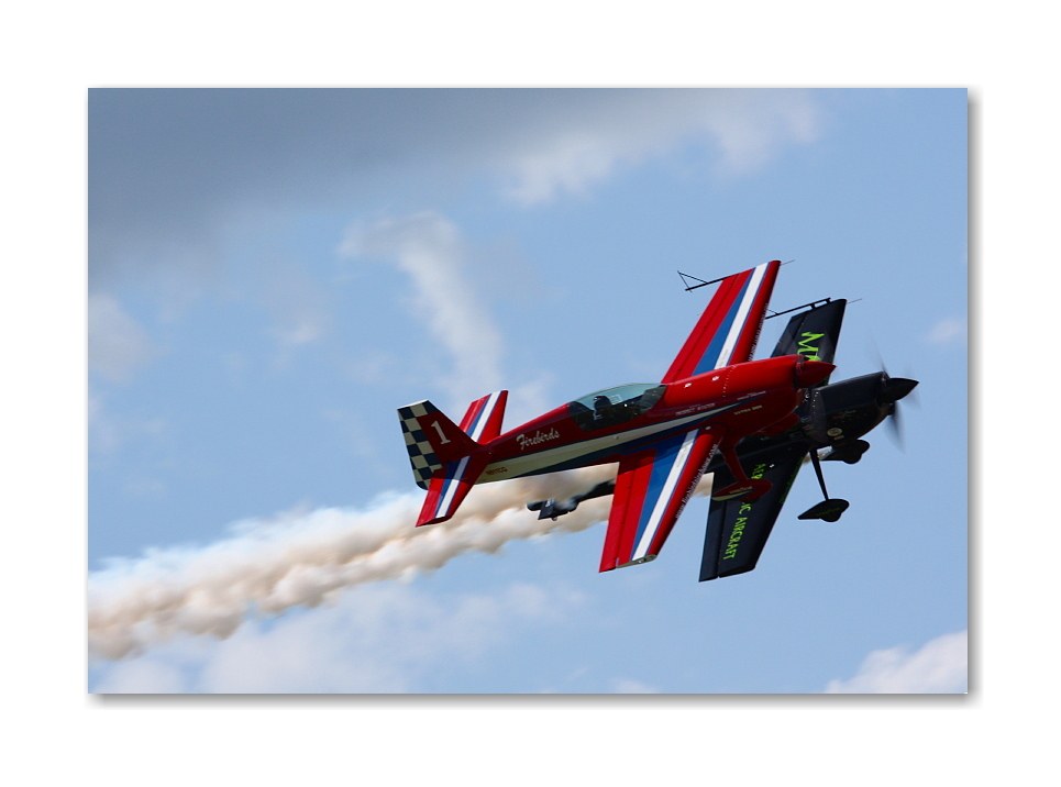 Red aerobatic plane in flight