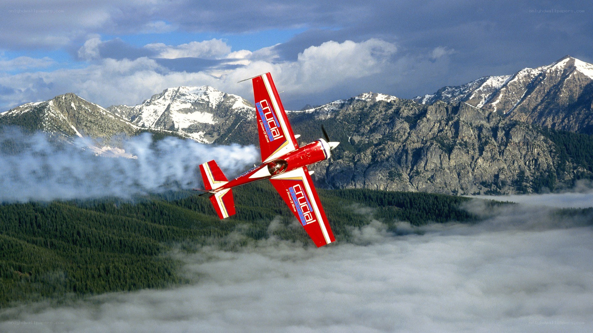 Red aerobatic plane over mountains