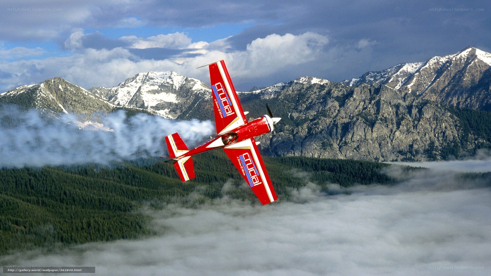 Red aerobatic plane over mountains