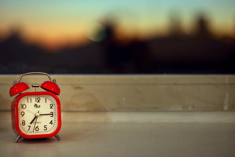 Red alarm clock on windowsill