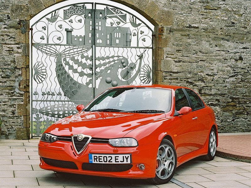Red Alfa Romeo in front of gate