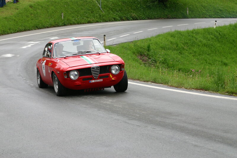 Red Alfa Romeo racing on a road