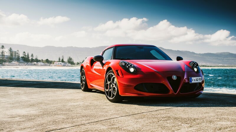 Red Alfa Romeo sports car by the sea