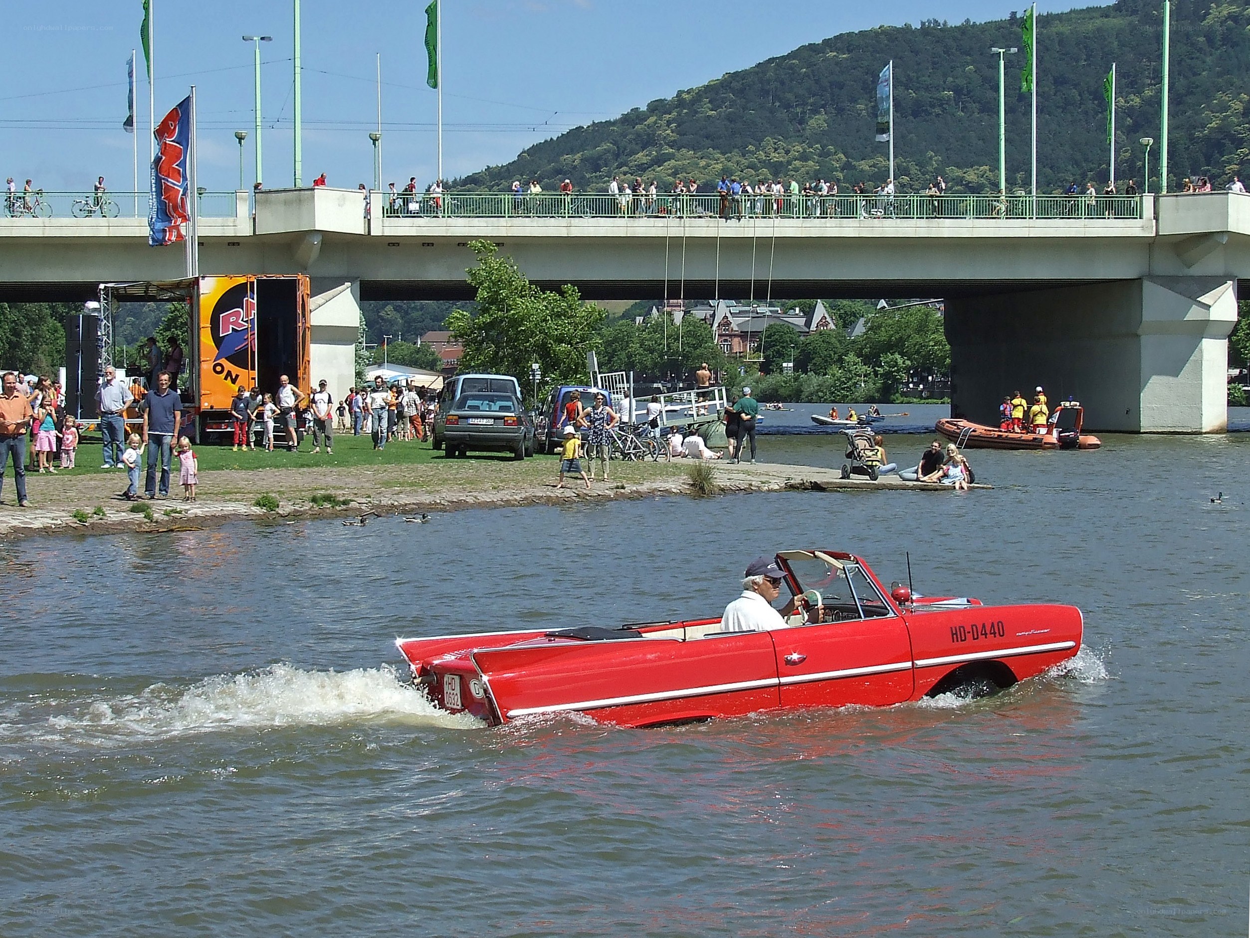 Red amphibious car on river