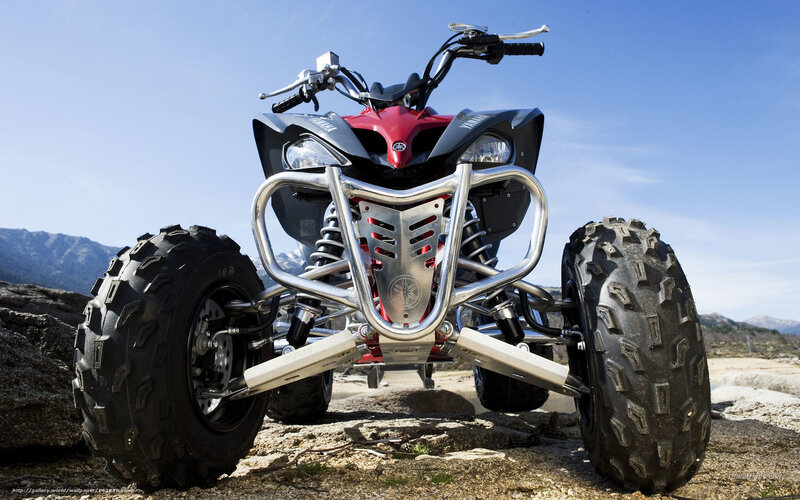 Red and black ATV on rocky terrain