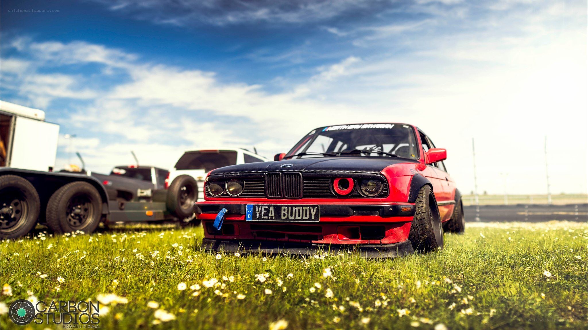 Red and black BMW on grass