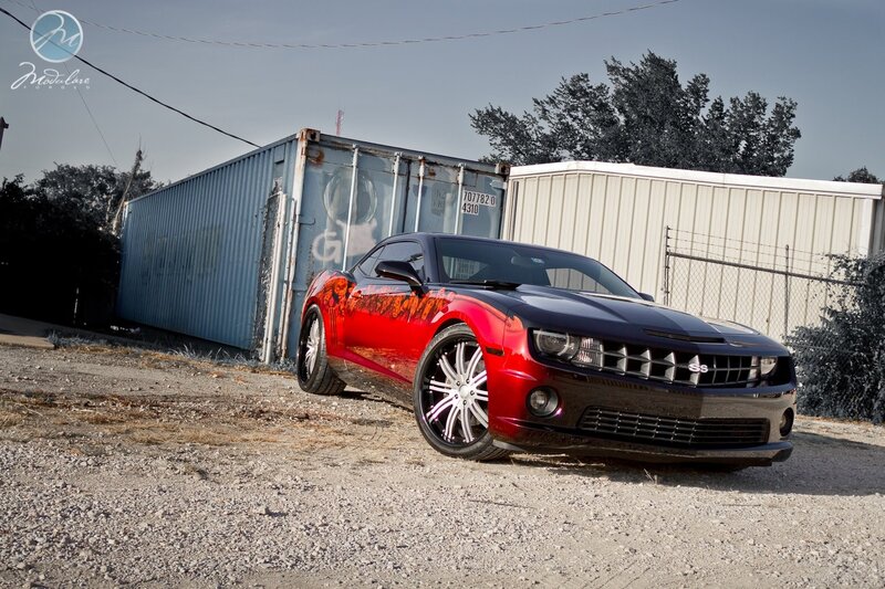Red and black Camaro in industrial area