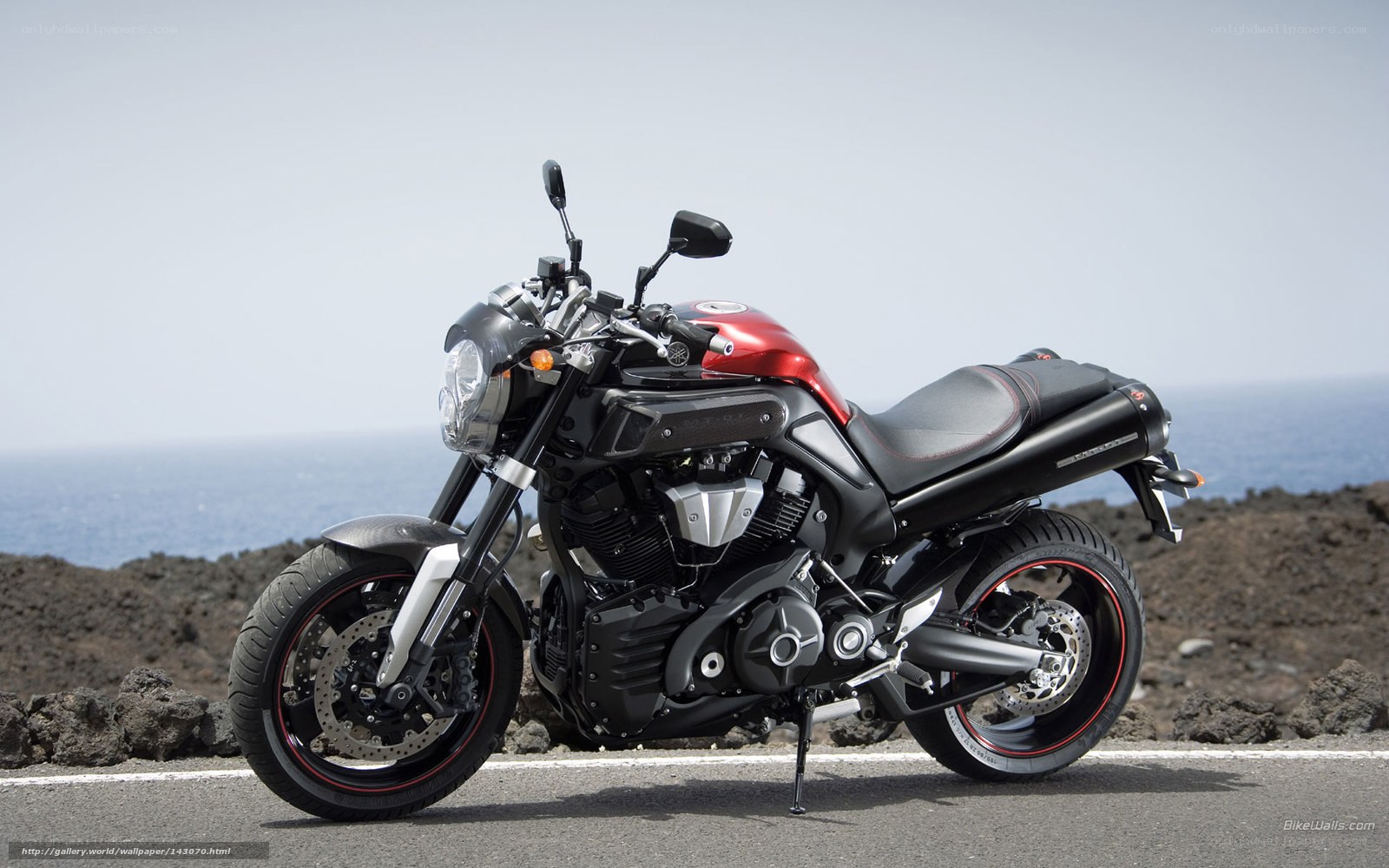 Red and black motorcycle by the sea