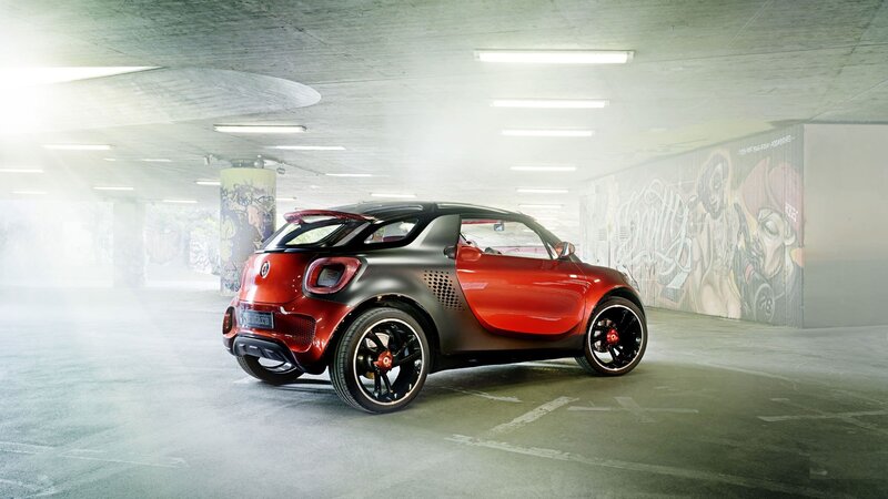 Red and black smart car in garage