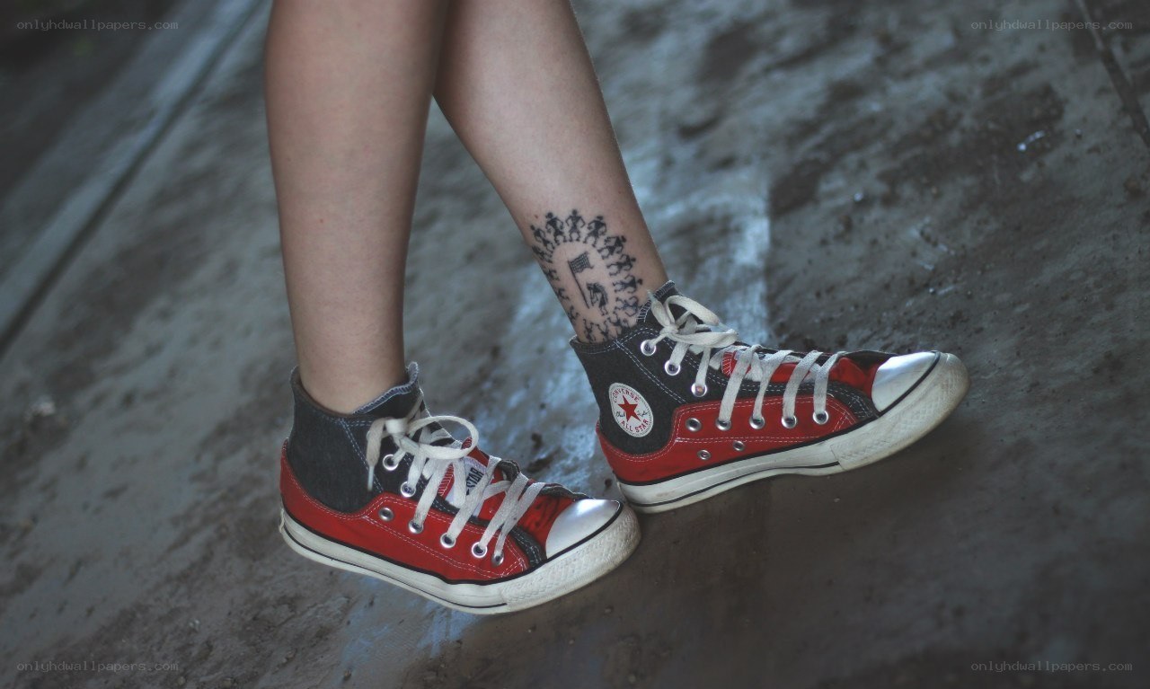 red and black sneakers with tattoo