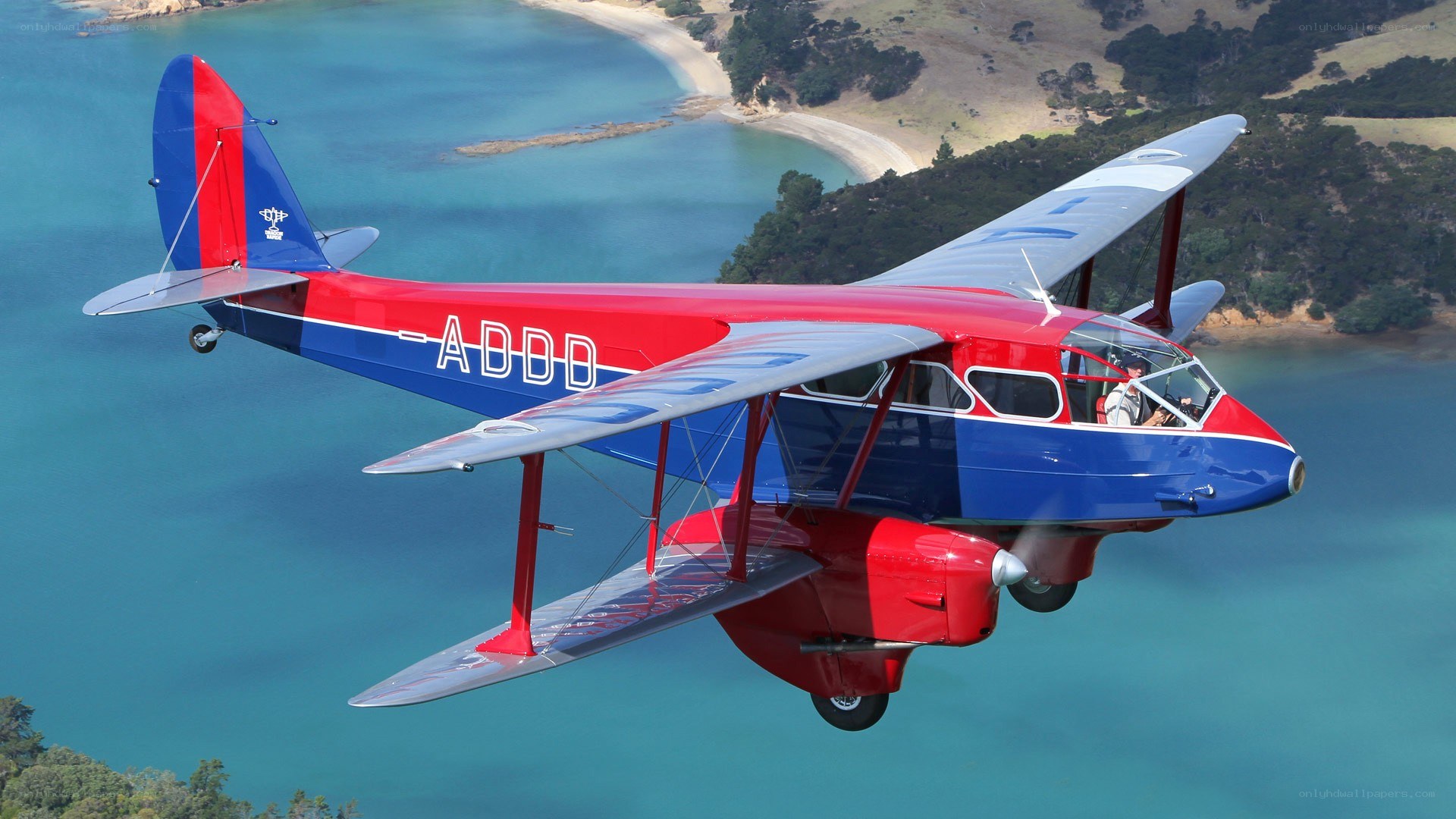 Red and blue biplane in flight