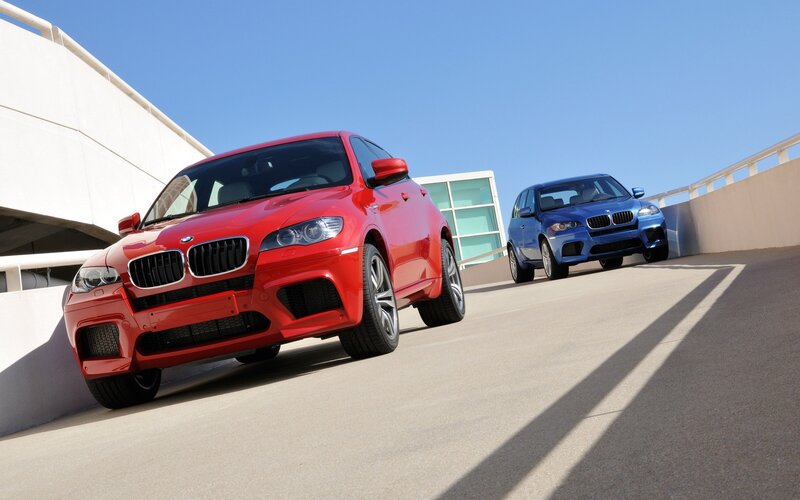 Red and blue BMW SUVs on ramp