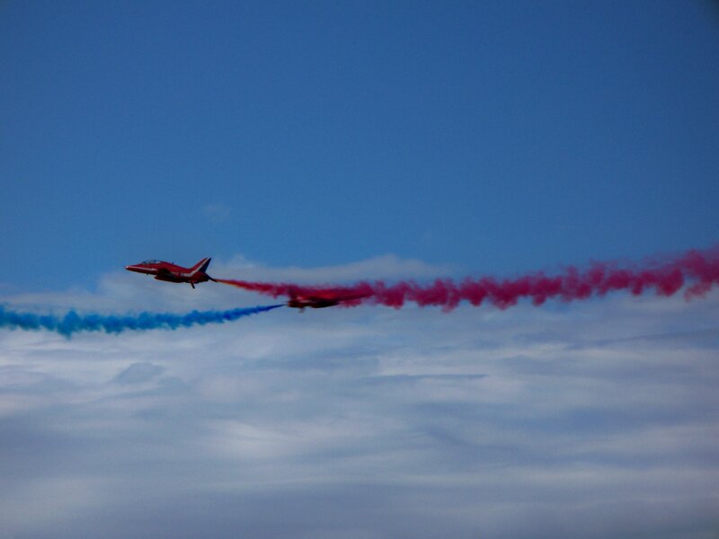 Red and blue smoke trails in sky