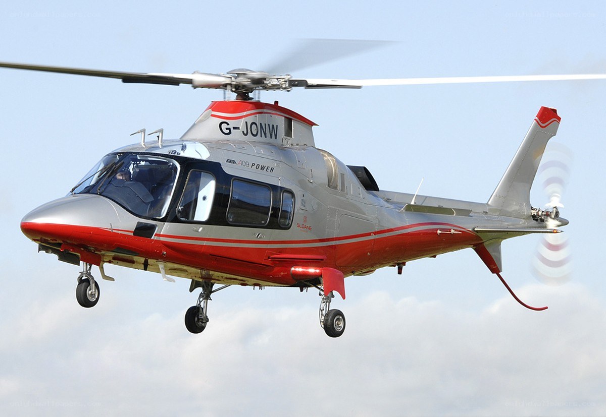 red and silver helicopter in flight