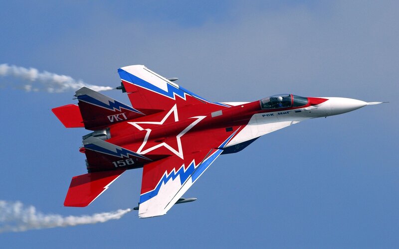 Red and white fighter jet in flight