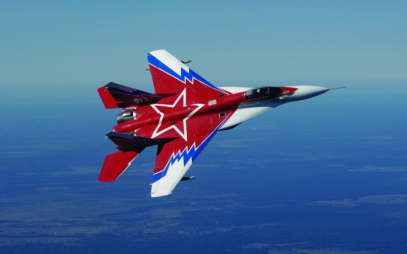 Red and white fighter jet in flight