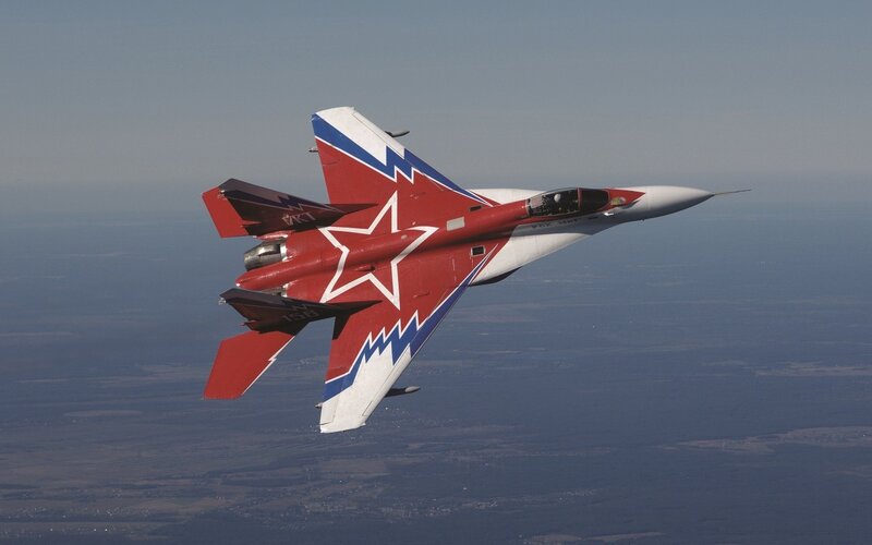 Red and white fighter jet in flight