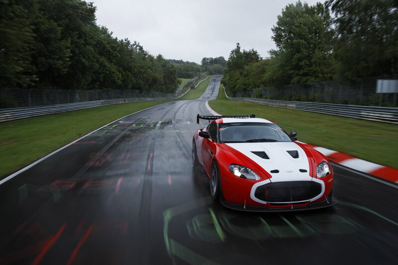 Red and white race car on wet track