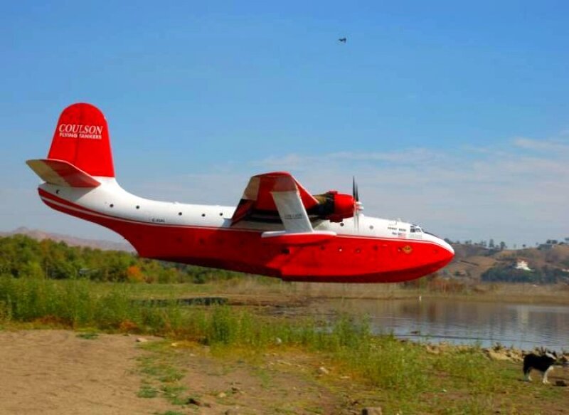 Red and white seaplane in flight
