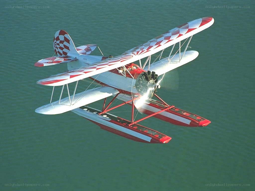 Red and white seaplane in flight