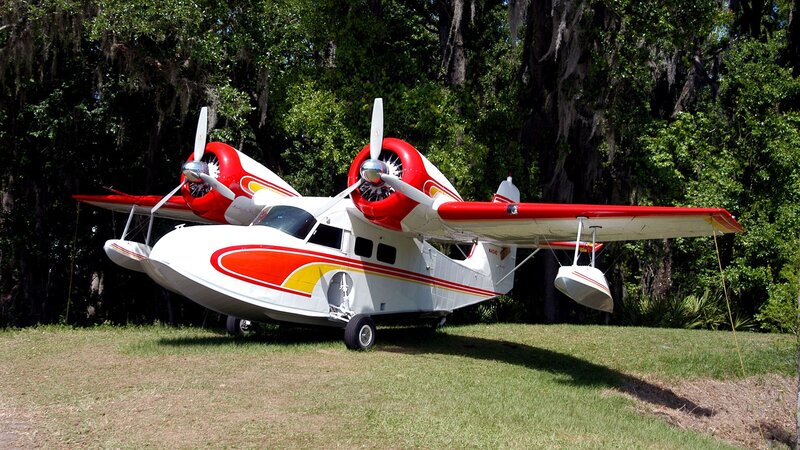 red and white seaplane on grass