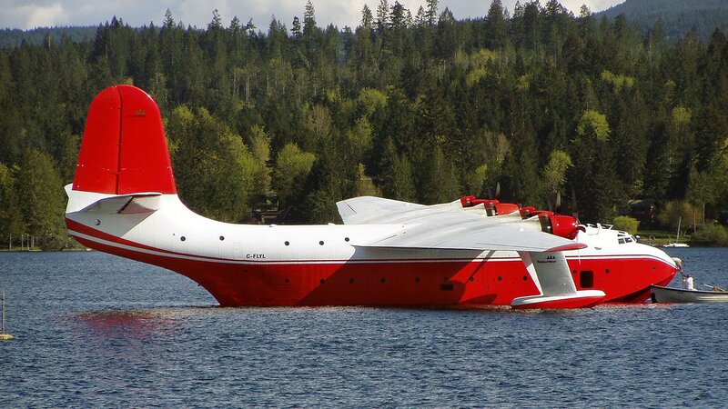 Red and white seaplane on lake