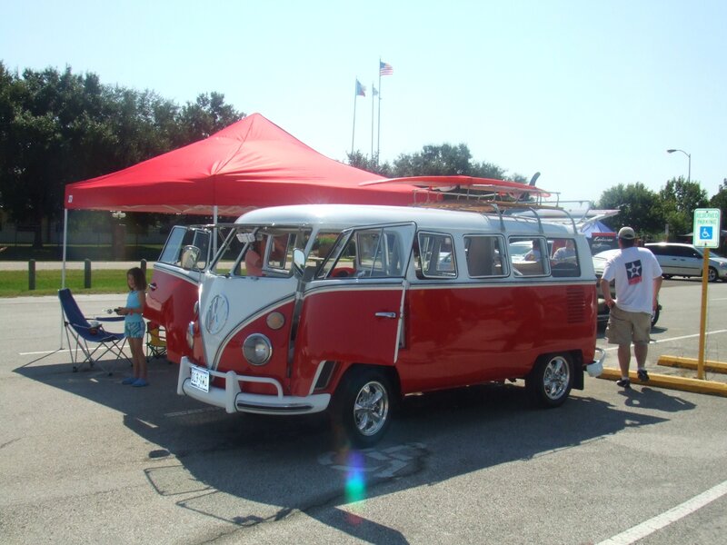 Red and white VW bus at outdoor event